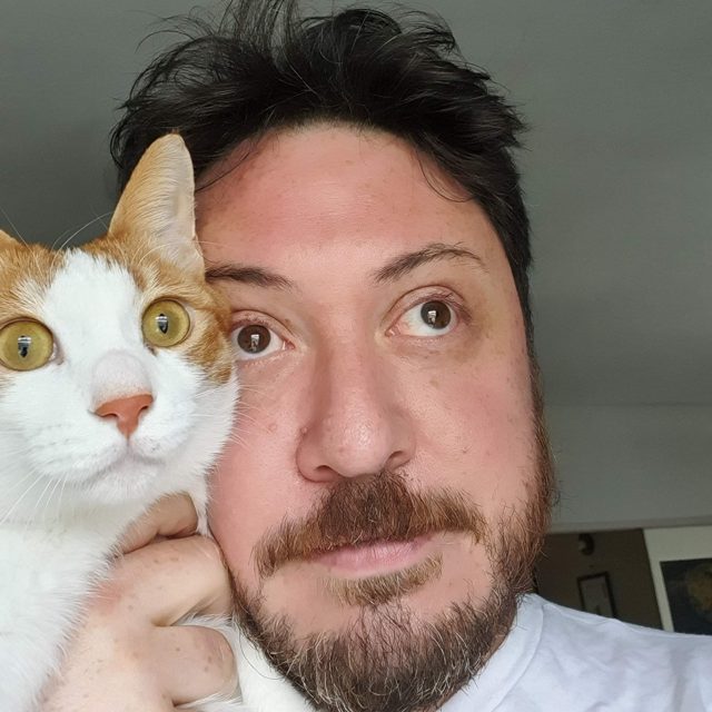 Daniel Scharf with his orange and white cat, Percy